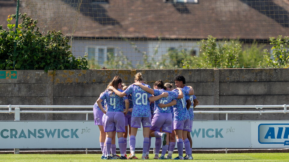 Norwich City Women huddle on the pitch 